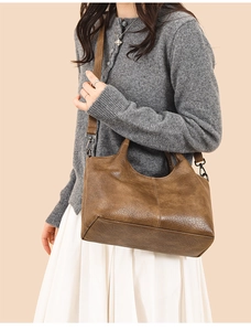 Brown vintage faux leather tote bag with shoulder strap shown on a model