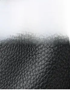 Dettaglio della texture in pelle nera con grana litchi su una borsa a secchiello