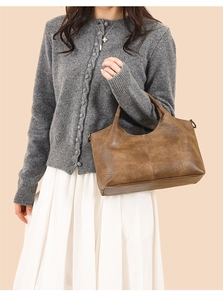 Brown vintage faux leather handbag styled with a knitted cardigan and white skirt