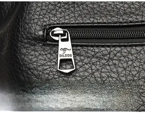 Macro shot of black pebbled leather texture with a silver metal kangaroo logo zipper