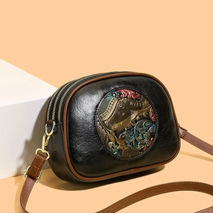 Retro embossed crossbody bag with three zippers and vintage metal plate in beige studio