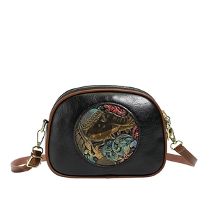 Black leather semicircular crossbody bag with elephant embossing and brown strap