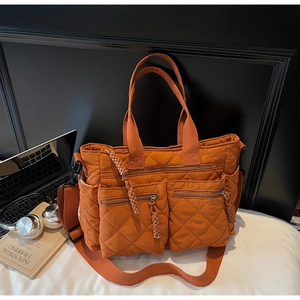 Detail of orange quilted tote bag with large zipper pockets for office and daily commute