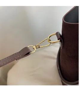Detail of durable gold metal carabiner hook and premium brown suede strap on tote bag