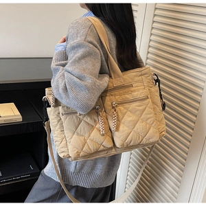 Detail of khaki quilted tote bag with multi-pocket design and nylon texture