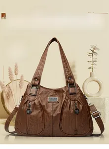 Macro view of vintage brown pebbled leather texture and metal brand tag on handbag