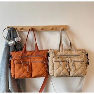 Detail of quilted nylon tote bags with side pockets and adjustable shoulder straps