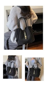Close-up of black suede bucket bag with leather trim and gold metal buckle clasp