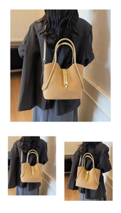 Detail of camel suede tote bag showing round handle and golden metal buckle closure
