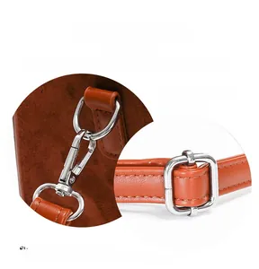Detail of silver carabiner and square adjustment buckle on brown suede handbag strap