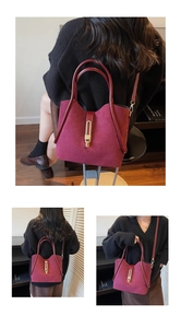 Detailed close-up of burgundy suede tote bag with gold metal buckle and dual leather straps