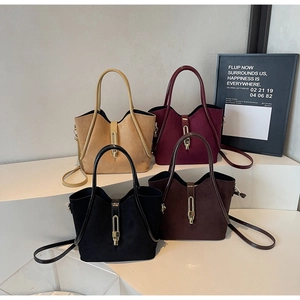 Detail of four retro suede bucket bags in burgundy and black with gold metal locks