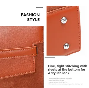 Detail of orange-brown leather bag with precision stitching and silver metal protective studs