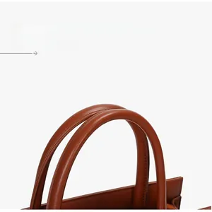 Detailed close-up of brown faux leather tote handles with precision stitching and texture