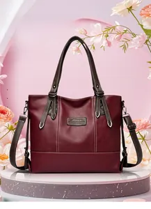 Burgundy tote bag with brown straps and white contrast stitching on display stand