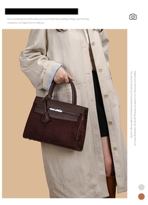 Detail of elegant wine red handbag with leather strap and metallic twist lock closure