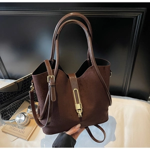Detail of coffee brown tote bag featuring matte suede material and gold metal clasp
