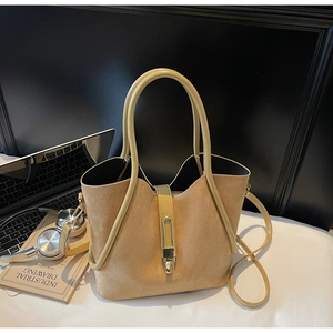 Close-up of khaki suede bucket bag with gold metal clasp and elegant V-shaped opening
