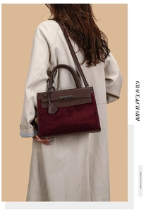 Detail of a brown leather and burgundy suede shoulder bag worn by a model in a trench coat