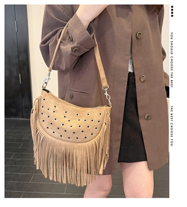 Détail du sac besace en daim kaki avec de longues franges et des œillets métalliques