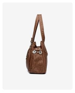 Detail view of brown vintage shoulder bag showing washed leather texture and metal buckle