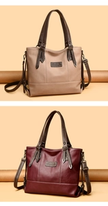 Detail of large leather tote bags in beige and burgundy with adjustable straps and logo