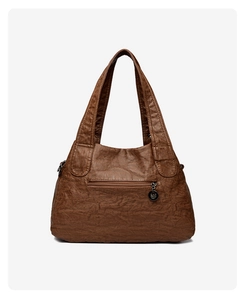 Close-up of the vintage brown litchi pattern leather bag back pocket and metal logo zipper