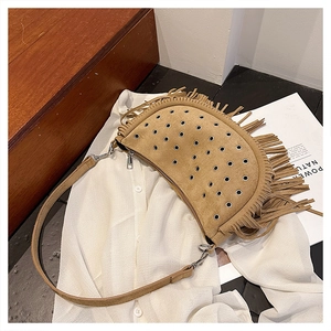 Détail du sac besace en daim fauve avec franges et œillets métalliques argentés