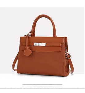 Detail of the brown dual-texture leather handbag with silver lock and top handle