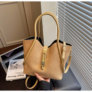 Macro view of khaki matte leather tote bag featuring a gold metal buckle detail