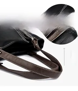 Detail of lychee pattern leather tote bag showing white contrast stitching and silver buckles