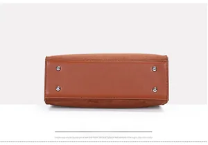 Detail view of the brown leather handbag base featuring four silver metal protective studs