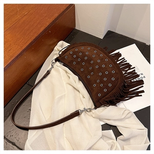 Détails du sac besace en daim marron avec œillets argentés et longues franges bohèmes