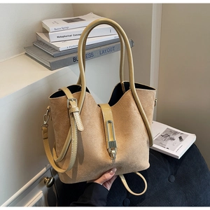 Detailed texture of suede tote bag featuring metallic clasp and wavy top edge design