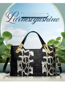 Detailed view of crocodile pattern texture and gold hardware on two-tone handbag