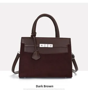 Detailed view of dark brown leather handbag featuring a classic gold metal buckle closure