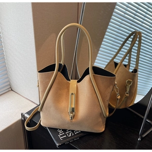 Detail of light khaki suede tote bag featuring a V-shaped opening and gold metal lock