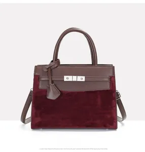 Detail of burgundy suede and brown leather splicing on a vintage trapezoid handbag
