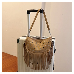 Gros plan d'un sac en daim marron avec de longues franges et des œillets métalliques