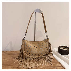 Détail d'un sac hobo bohème avec œillets argentés et longues franges décoratives