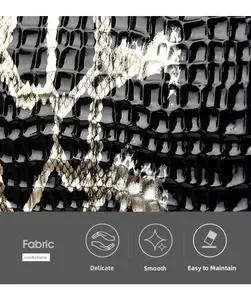 Close-up of black glossy crocodile textured leather fabric with comfortable smooth finish