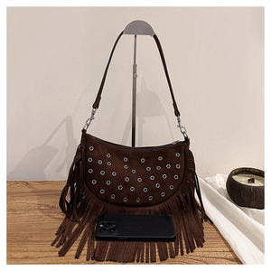 Détail du sac bandoulière en daim marron avec franges et œillets métalliques dorés