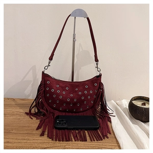 Détail du sac à franges bordeaux avec œillets métalliques et texture en daim