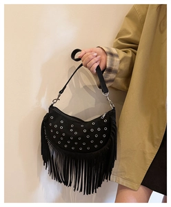 Détail du sac de selle bohème noir avec œillets métalliques argentés et longues franges