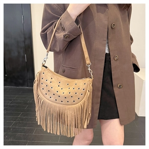Détail du sac bandoulière en daim kaki avec œillets métalliques et longues franges fluides