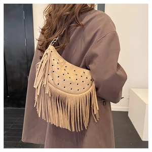 Détail du sac de selle bohème en daim camel avec franges et œillets métalliques