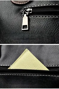 Detail of silver zipper puller and back pocket on black lychee grain leather tote bag
