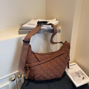 Brown quilted lattice crescent bag with adjustable wide strap and woven zip detail