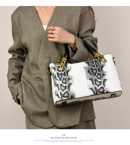 Detailed view of crocodile pattern texture and golden metal hardware on the tote bag