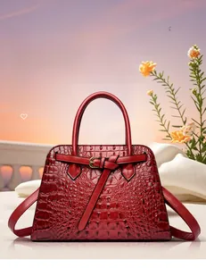 Detail of red crocodile texture tote with elegant golden metal buckle and leather strap